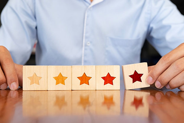 A man on a table puts together blogs with different colored stars on them