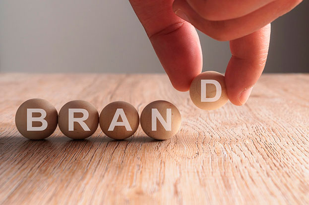Small round wooden balls creating the name brand together lined up on a table