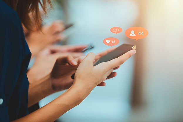 A group of people are holding phones in their hands receiving and exchanging messages and likes